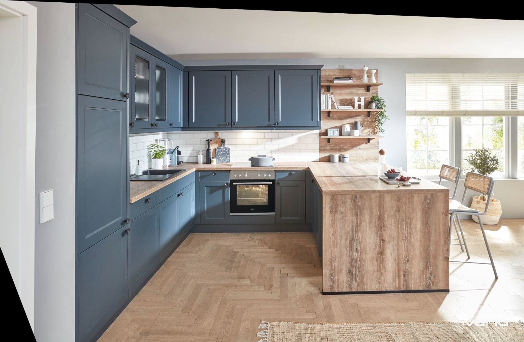 Blaue Landhausküche mit Holz-Halbinsel und Fischgrätparkett