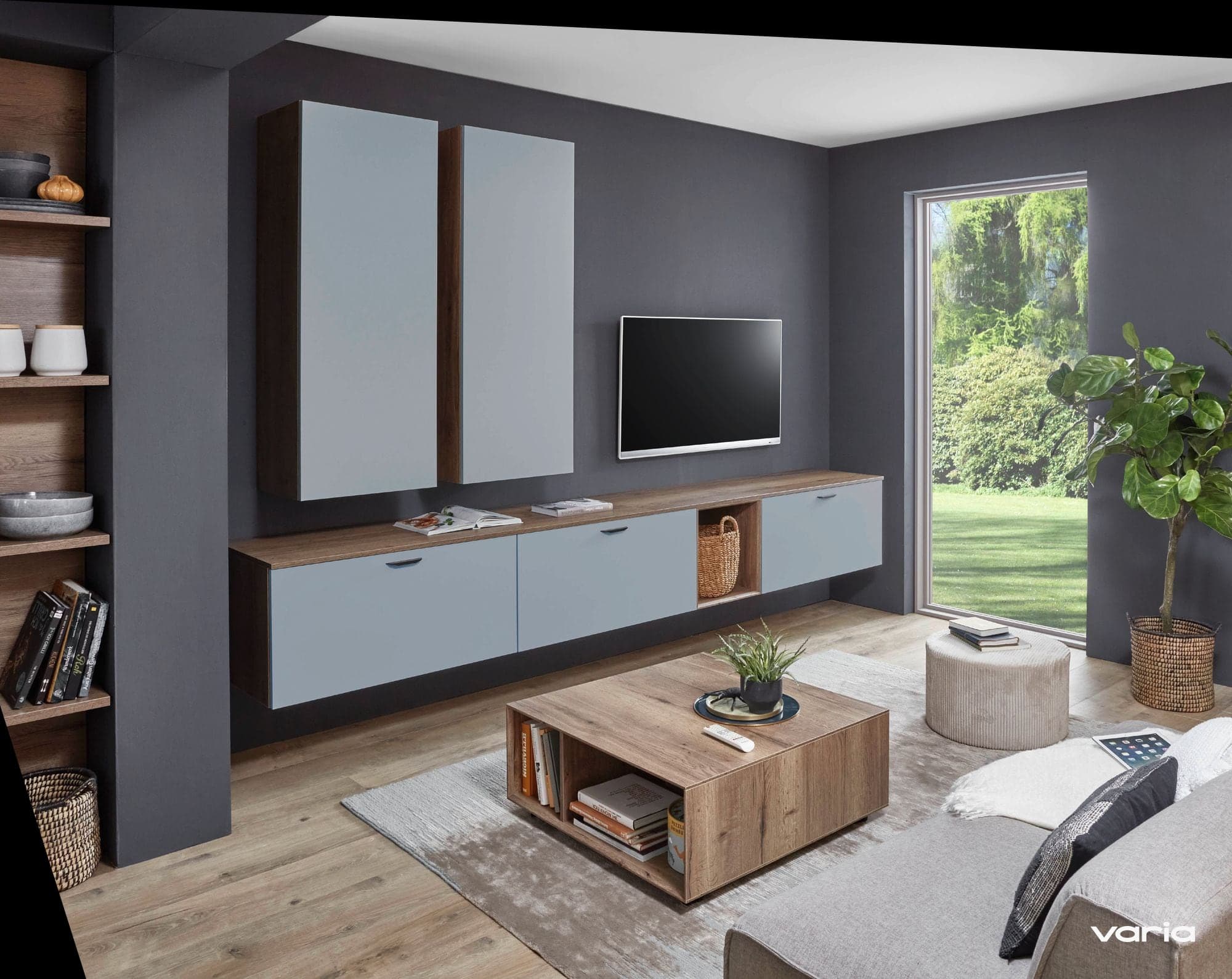 Wohnzimmerwand aus Küchenmöbeln: Sideboard, Hängeschränke und Fernseher in Graublau und Holz